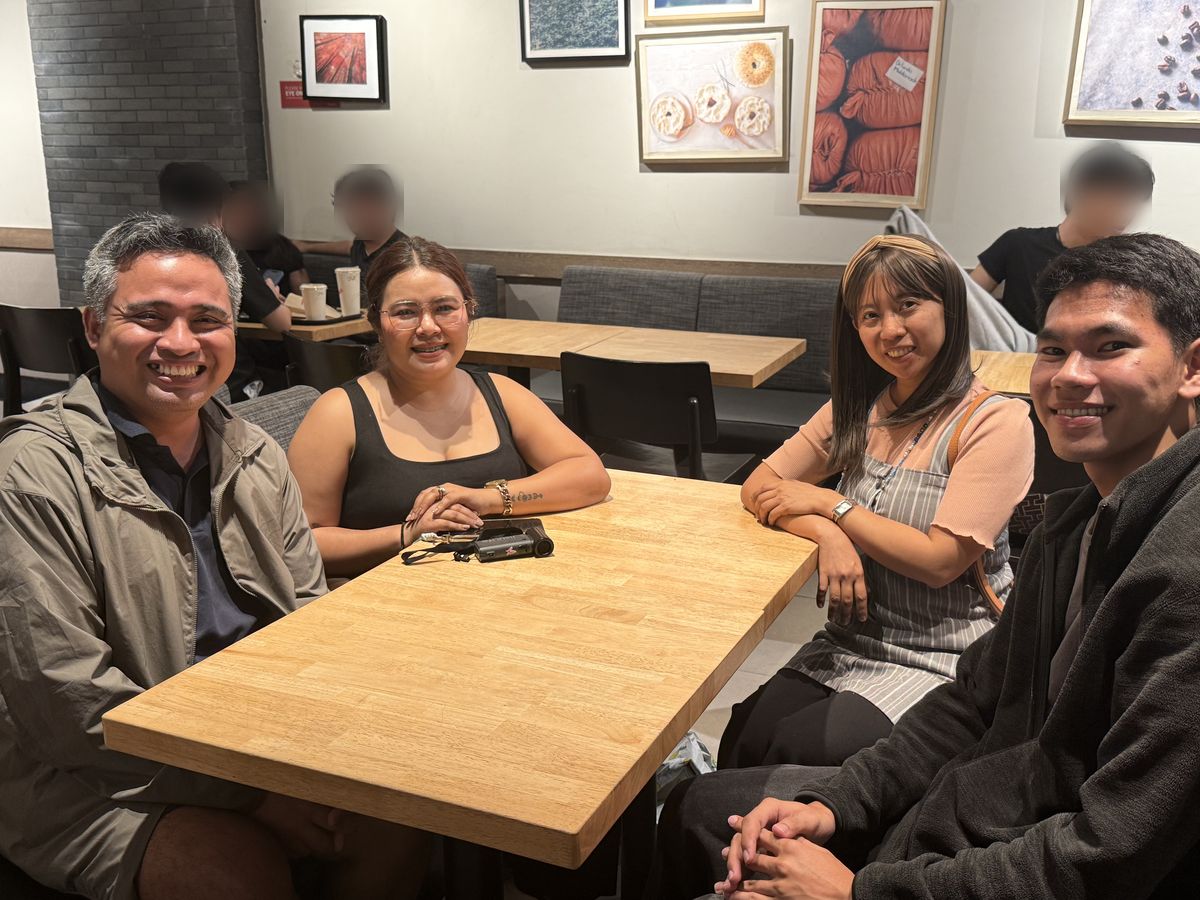 Jonathan, Shana, Joy and Reggie smiling around a table in a coffee shop